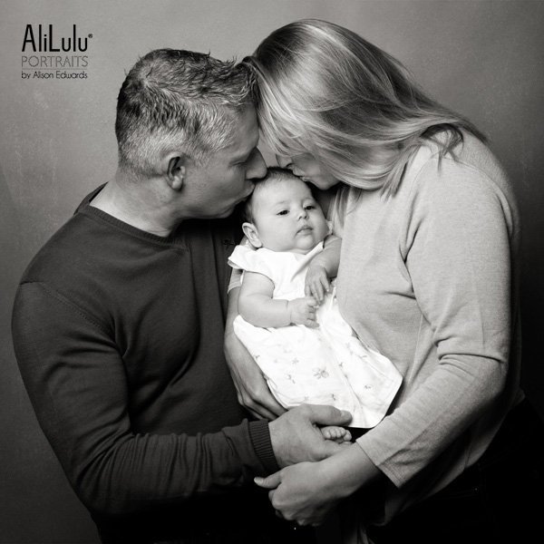 mum and dad kissing baby girl aged 10 weeks old